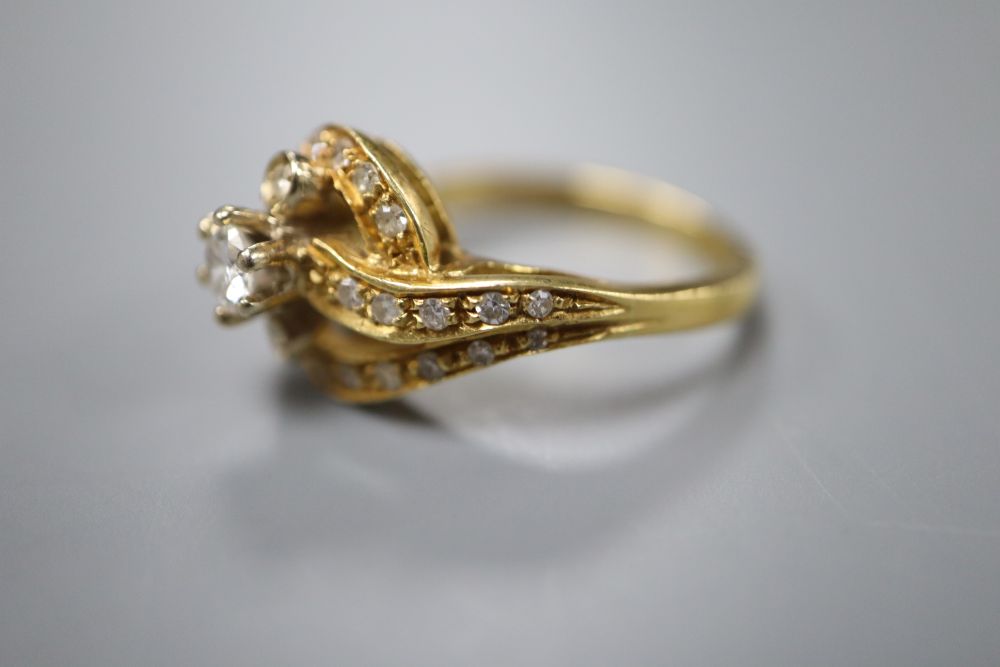 An 18ct yellow gold and diamond ring of scroll design, size O, gross 6 grams.